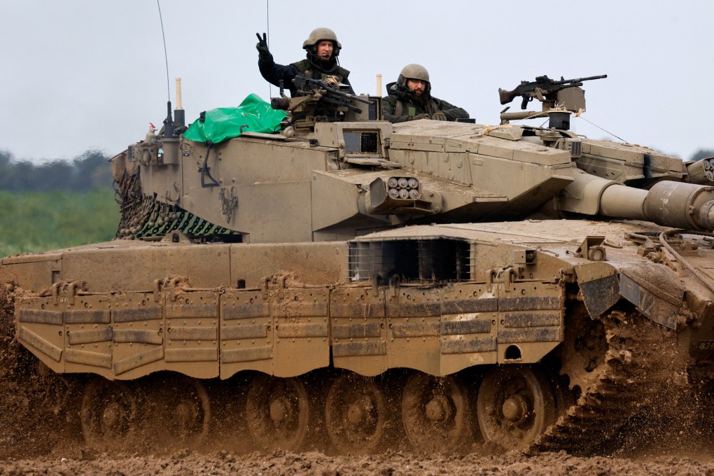 An Israeli soldier gestures to the camera as he rides in a tank near the Israel-Gaza border on Saturday. Photo: Reuters