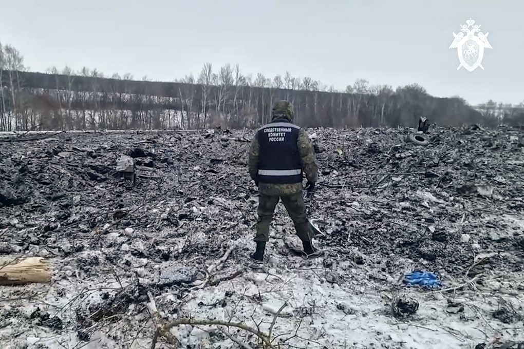 A Russian Investigative Committee employee walks by the wreckage of the Il-76 near Yablonovo, in the Belgorod region of Russia on Thursday. Photo: Russian Investigative Committee via AP