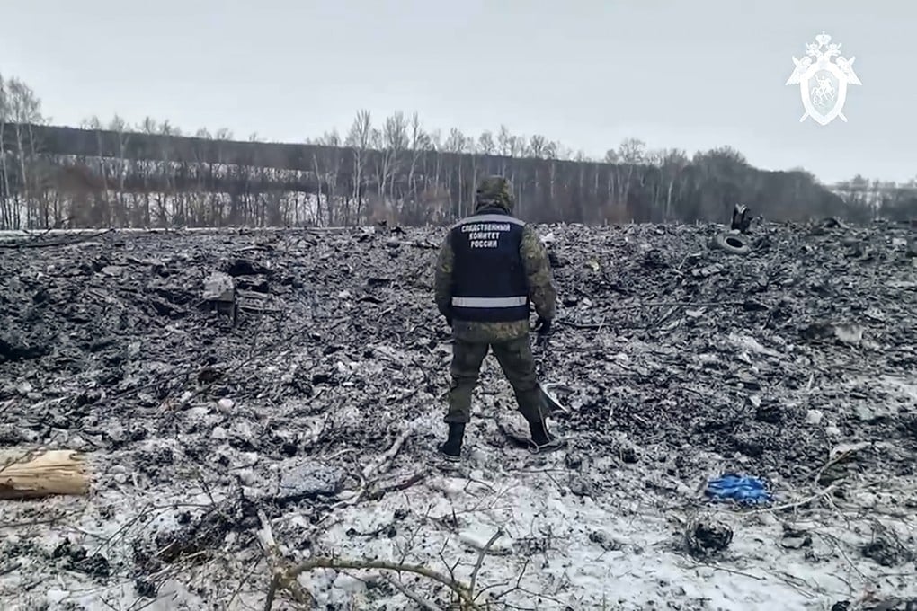 A Russian Investigative Committee employee walks by the wreckage of the Il-76 near Yablonovo, in the Belgorod region of Russia on Thursday. Photo: Russian Investigative Committee via AP