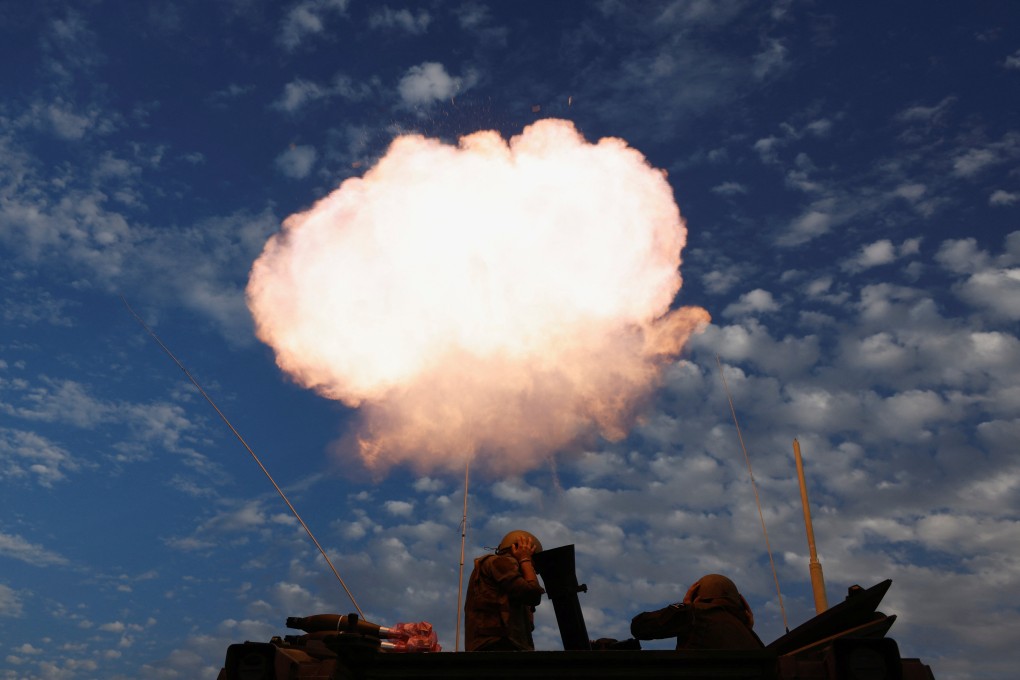 Israeli soldiers near the Gaza border fire a mortar. Photo: Reuters