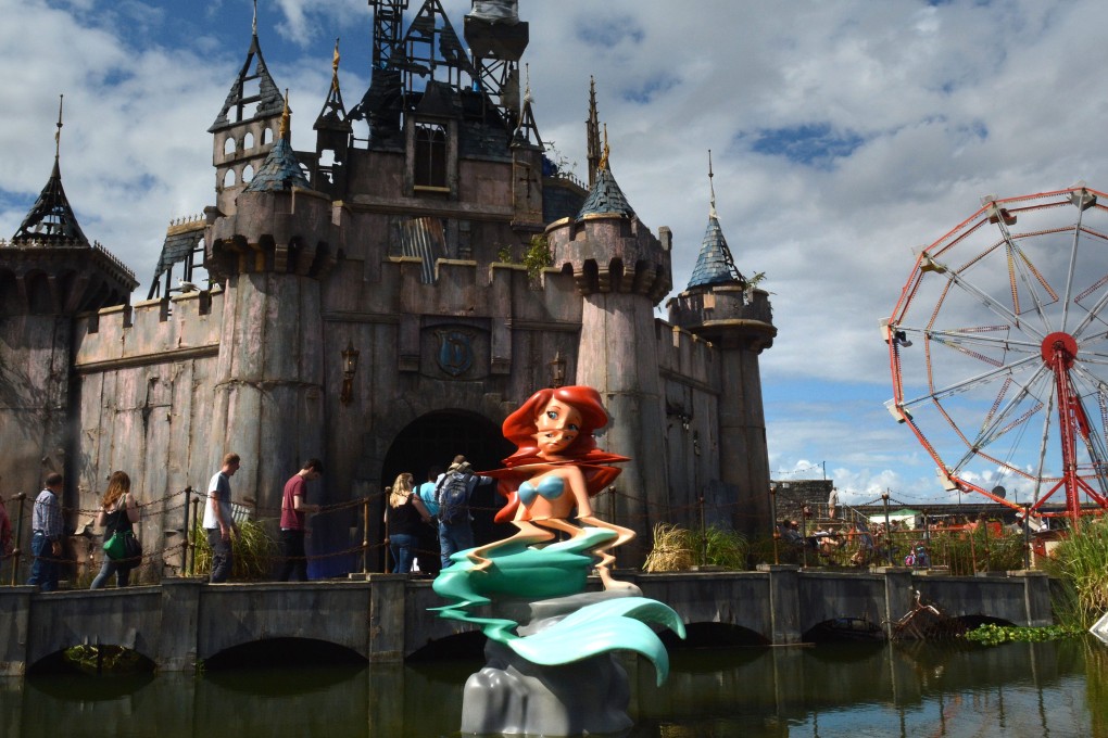 A mermaid sculpture sits in front of a fairy castle at Banksy’s Dismaland amusement park parody in Weston-super-Mare, England, in 2015. Photo: Getty Images