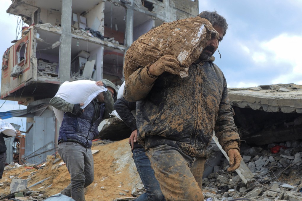 Palestinians carry bags of flour they grabbed from an aid truck near an Israeli checkpoint, as Gaza residents face crisis levels of hunger, amid the ongoing conflict between Israel and Hamas, in Gaza City. Photo: Reuters