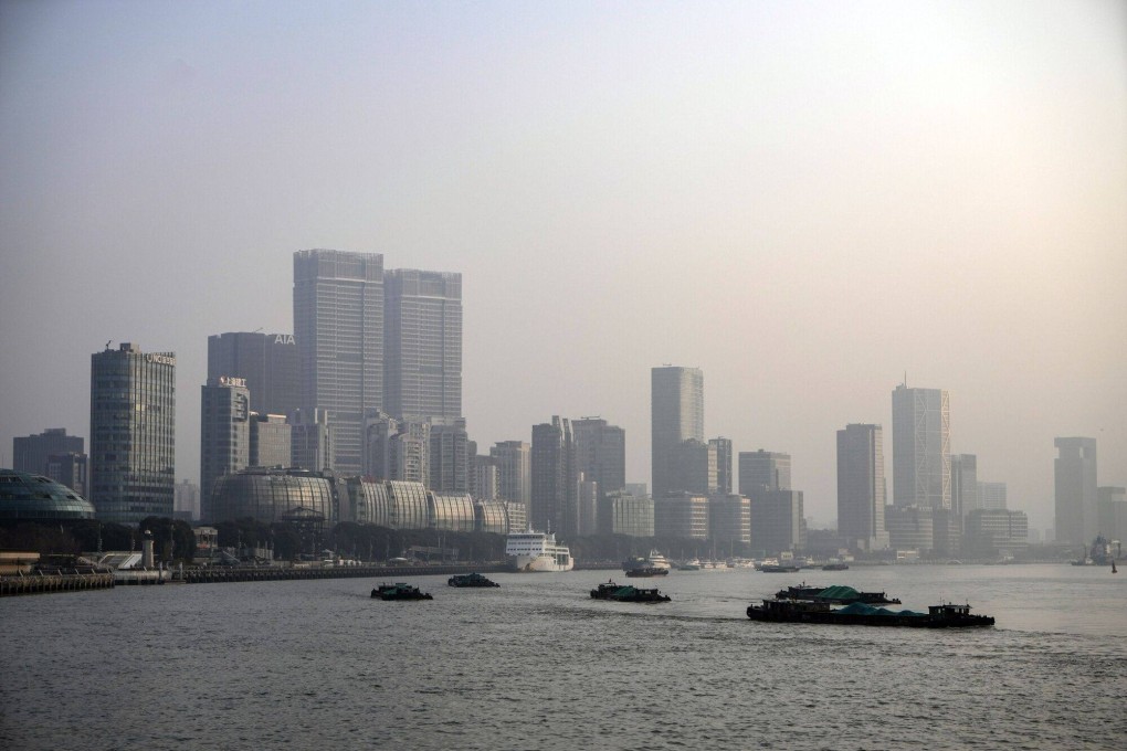 Barges move along the Huangpu River in front of buildings in Pudong’s Lujiazui Financial District in Shanghai, China. Photo: Bloomberg