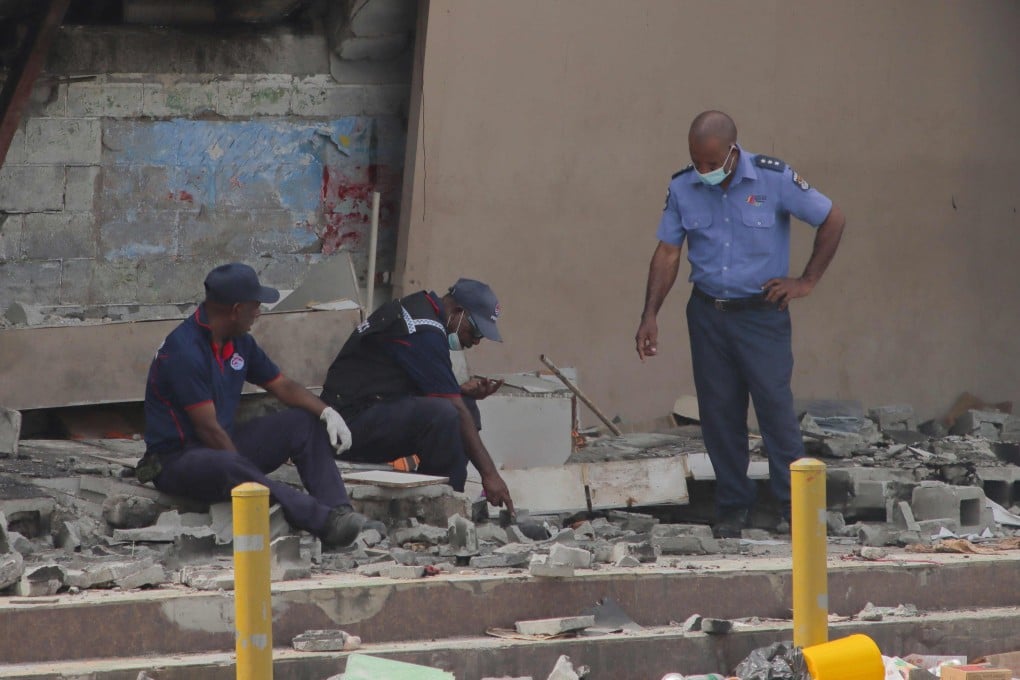 Police work at the site of a damaged building in Port Moresby on January 12. Deadly riots in Papua New Guinea laid bare the impoverished nation’s growing reliance on private security firms in place of police. Photo: AFP