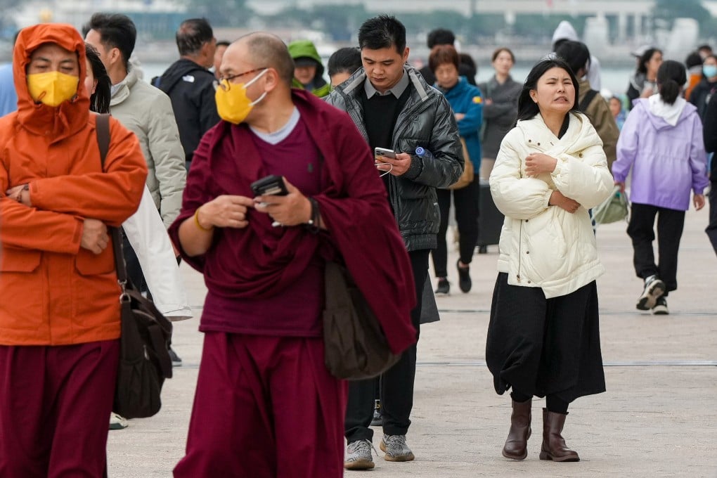 Pedestrians walk along Tsim Sha Tsui promenade. Observatory warned of “appreciably cooler” weather ahead of the Lunar New Year. Photo: Eugene Lee
