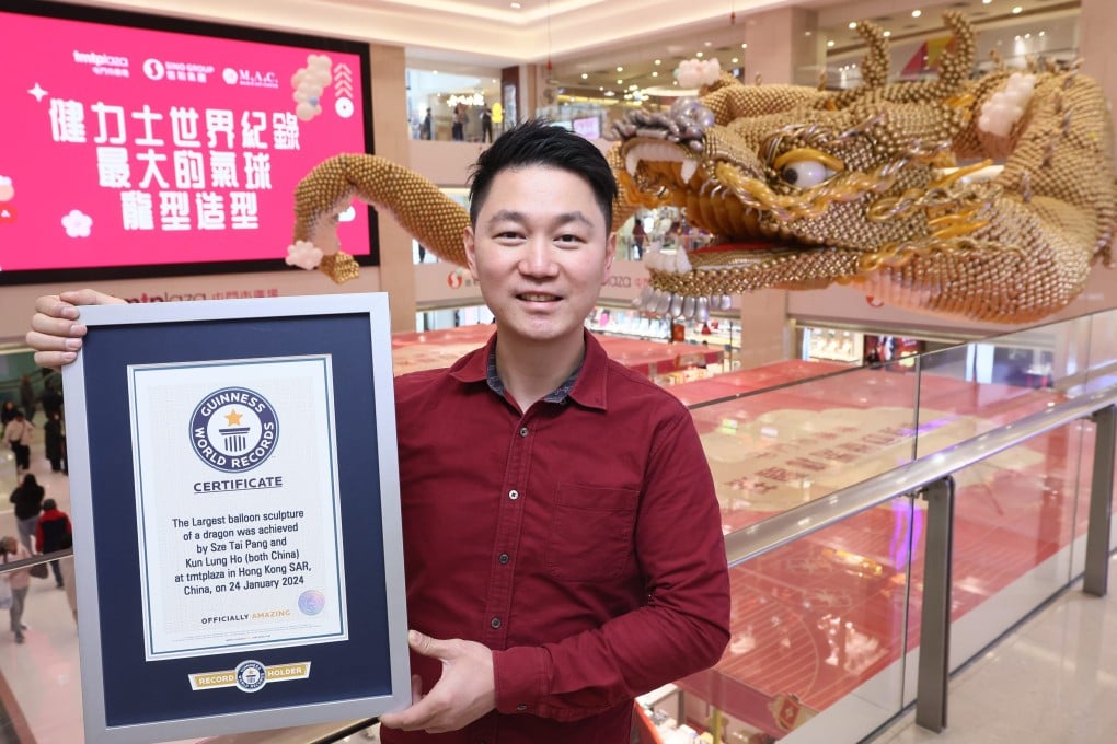 Balloon artist Wilson Pang with his 42-metre dragon sculpture - created to usher in the Year of the Dragon - and Guinness World Record certificate for the “largest balloon sculpture of a dragon” at TMTPlaza in Tuen Mun, Hong Kong. Photo: TMTPlaza