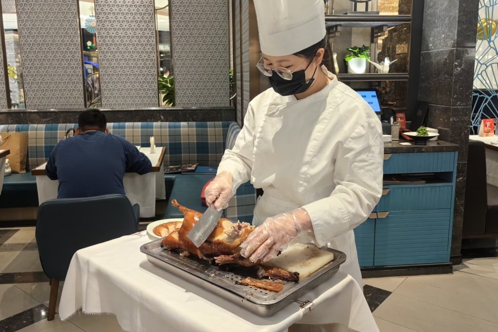 A server slices a course of Beijing fruitwood roast duck at Blossom Palaces in Shenzhen, China, where one of our writers eats on their day of food, drink and leisure in the city to compare it with Hong Kong. Photo: Young Wang