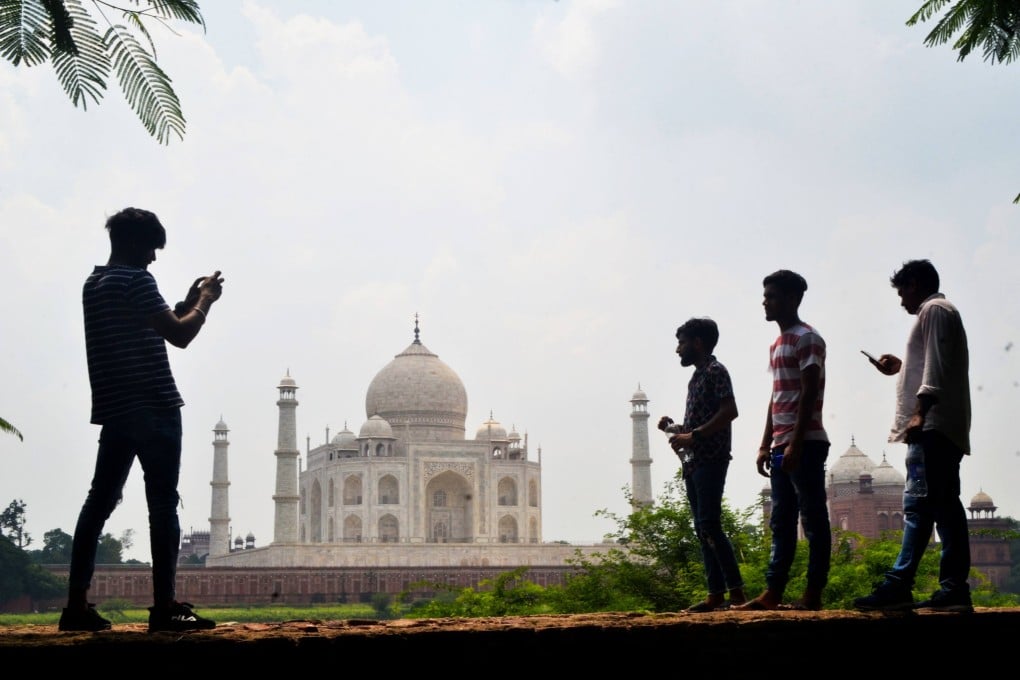 Young people take pictures with their mobile phones in Agra. Photo: AFP