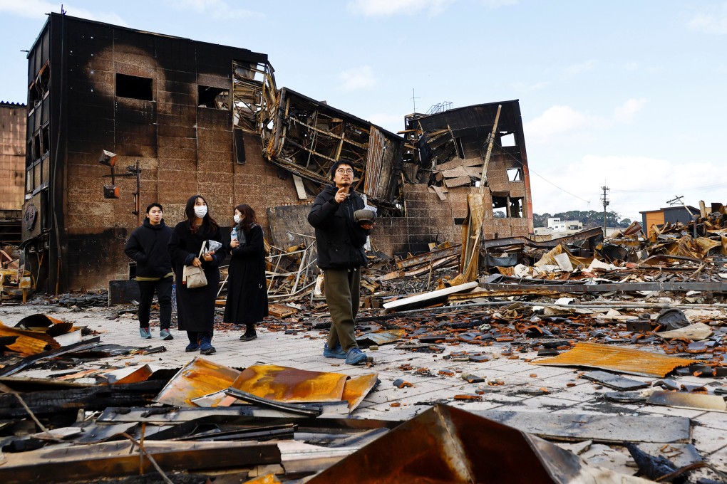 Lacquer artist Kohei Kirimoto searches for his missing cats near to an “Asaichi” morning market which burnt down in a quake-triggered fire, in Wajima, Japan. Photo: Reuters
