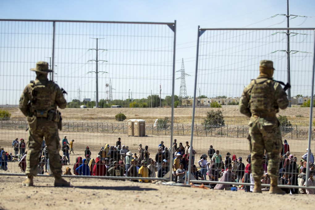 Migrants wait to enter into El Paso, Texas, under the watch of the Texas National Guard. File photo: AP
