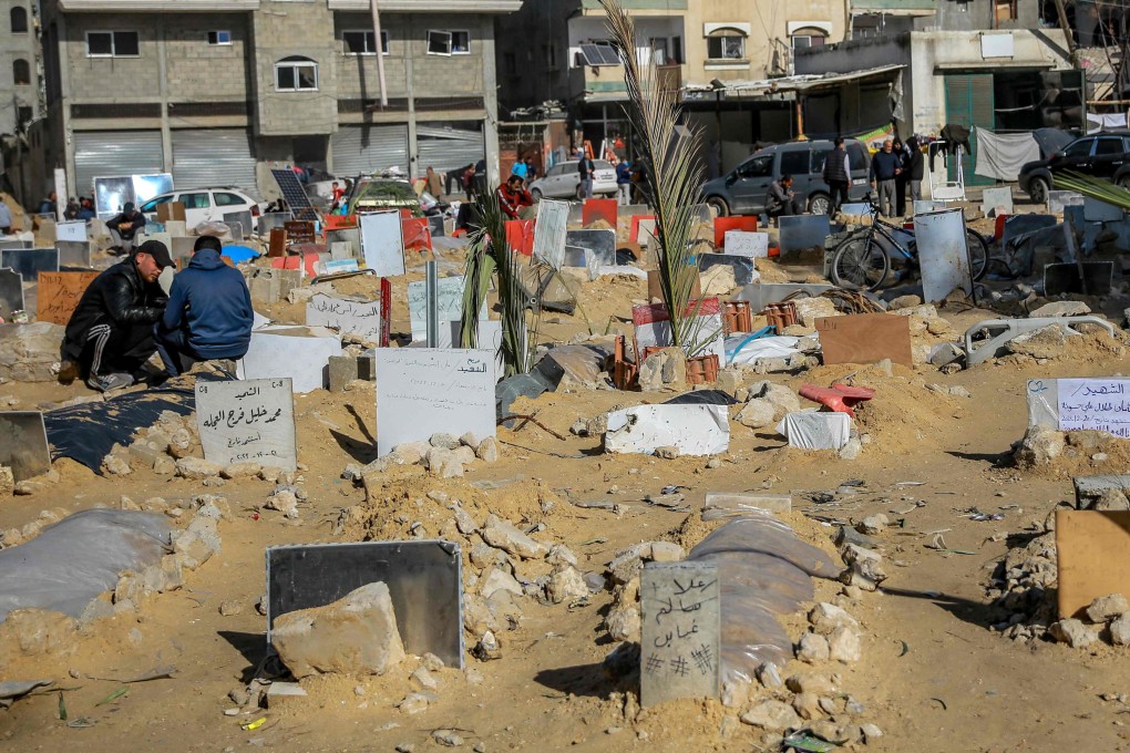 Placards indicating the names of people killed in Israeli bombardments are placed on shallow tombs at a makeshift cemetary in the vicinity of Al-Shifa Medical Complex in Gaza City. Photo: AFP