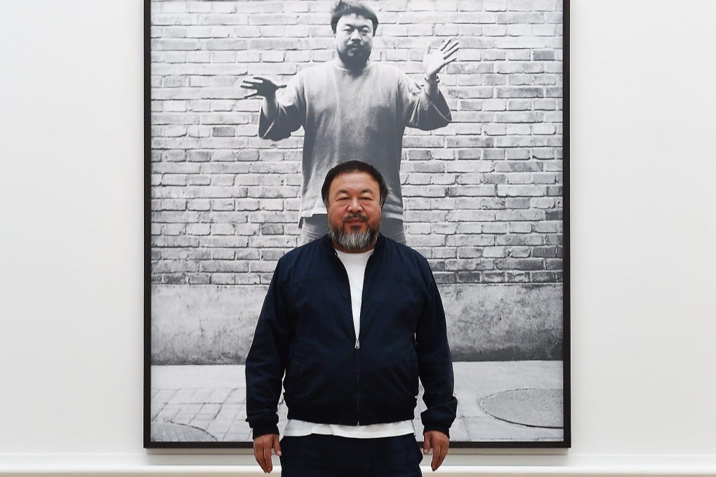 Chinese artist Ai Weiwei stands with his artwork ‘Coloured Vases’ (2015) during the unveiling of his new exhibition at the Royal Academy of Arts in London, United Kingdom on September 15, 2015. Photo: EPA