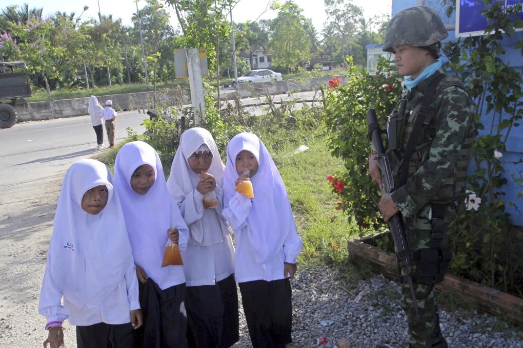 Muslim students walk pass a Thai soldier outside a school in Pattani province, southern Thailand, in 2013. Photo: EPA
