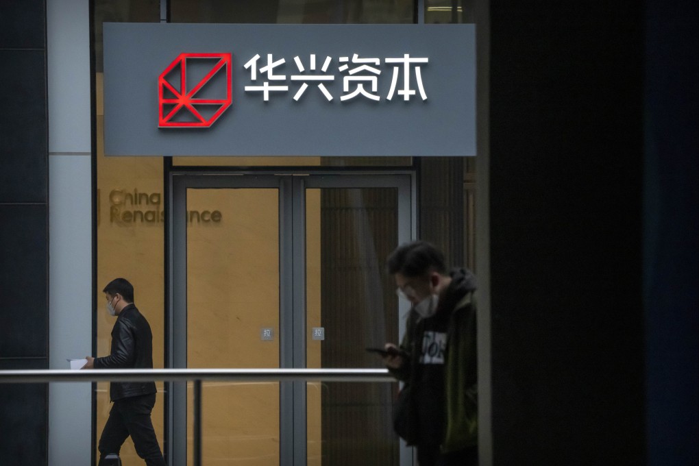 People walk past a China Renaissance office at an office building in Beijing. Photo: AP