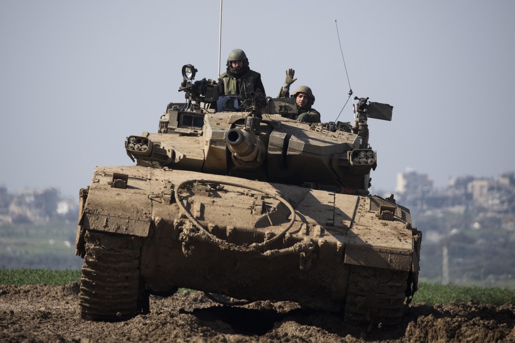 An Israeli tank moves along the border with Gaza in southern Israel on Tuesday. Photo: TNS