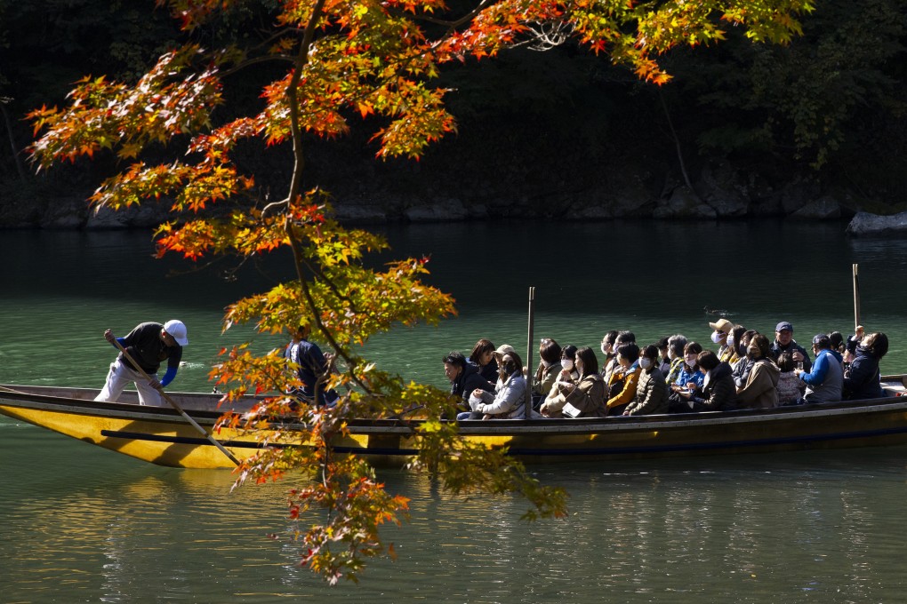 Tourists observe autumn foliage at the Oi River in Arashiyama, Kyoto. Photo: Getty Images