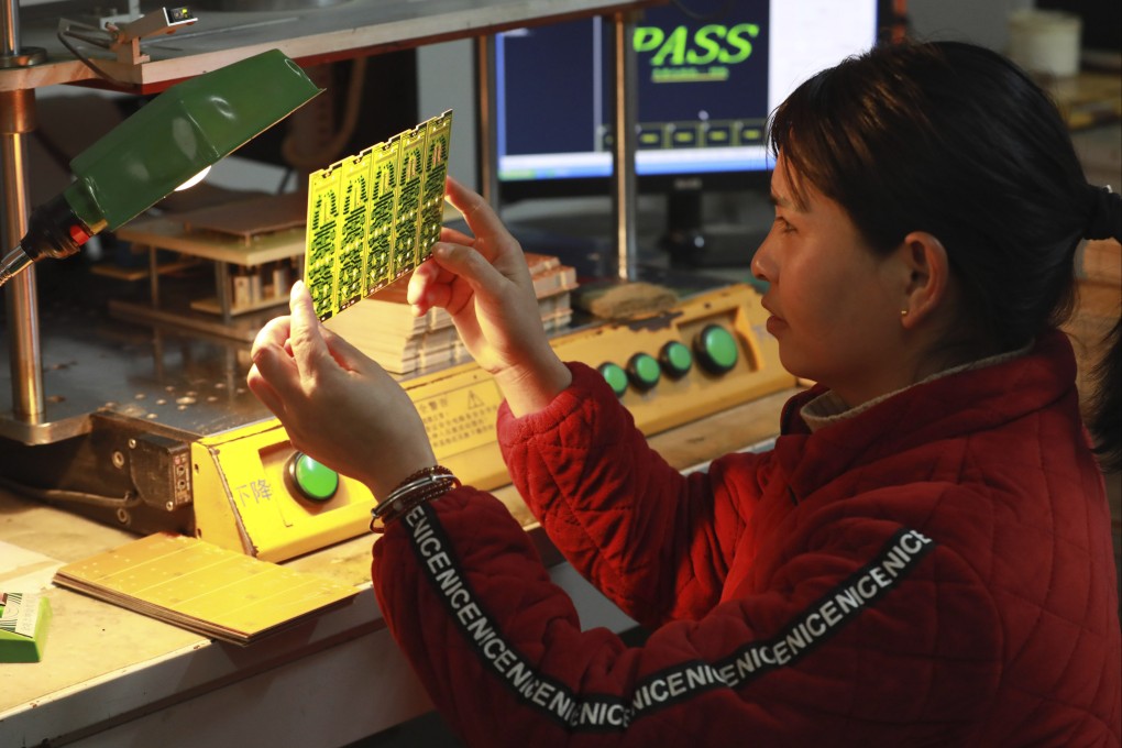 A worker examines a printed circuit board at a factory in Hangzhou in eastern China’s Zhejiang province. The country’s producer price index fell for the 16th month in a row, dropping by 2.5 per cent in January from a year earlier. Photo: AP