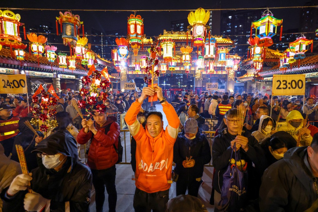Worshippers offer the first joss sticks at Wong Tai Sin Temple on Lunar New Year’s Eve, as a part of festive celebrations to usher in the Year of the Dragon. Photo: Yik Yeung-man
