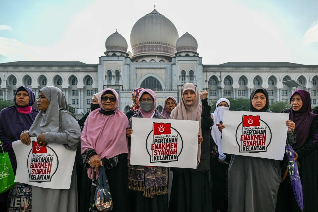 Members of the Pan-Malaysian Islamic Party display placards reading “Maintain the Kelantan Sharia Enforcement” outside the Palace of Justice in Putrajaya on February 9, 2024. Photo: AFP