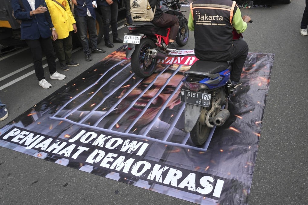 A banner with an image depicting Indonesian President Joko Widodo behind bars is laid out on the road during a rally demanding a fair presidential election. Students claim the president has been acting neutral in the election. Photo: AP
