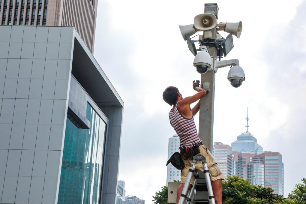 A worker installs CCTV cameras outside the Hong Kong government offices in Admiralty in 2019. Photo: Felix Wong