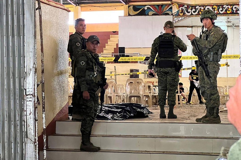 Military personnel stand guard at the entrance of a gymnasium while police investigators look for evidence after a bomb attack at Mindanao State University in Marawi. Photo: AFP