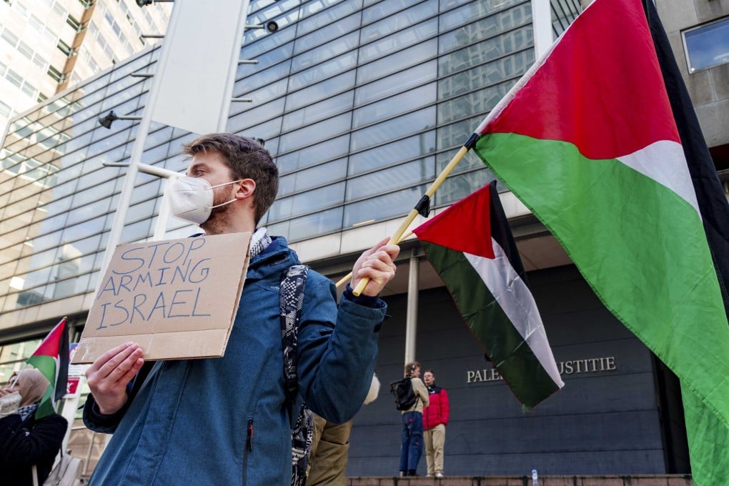 People carry Palestinian flags as they protest prior to the verdict in an appeal by human rights organisations for the Netherlands to stop delivering parts for F-35 fighter jets to Israel. Photo: EPA-EFE