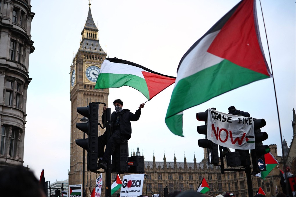 A pro-Palestinian supporter waves a Palestinian flag outside the Palace of Westminster, home to the Houses of Parliament in London. Labour has withdrawn support for candidate Azhar Ali after he was recorded discussing conspiracy theories about Israel. Photo: AFP