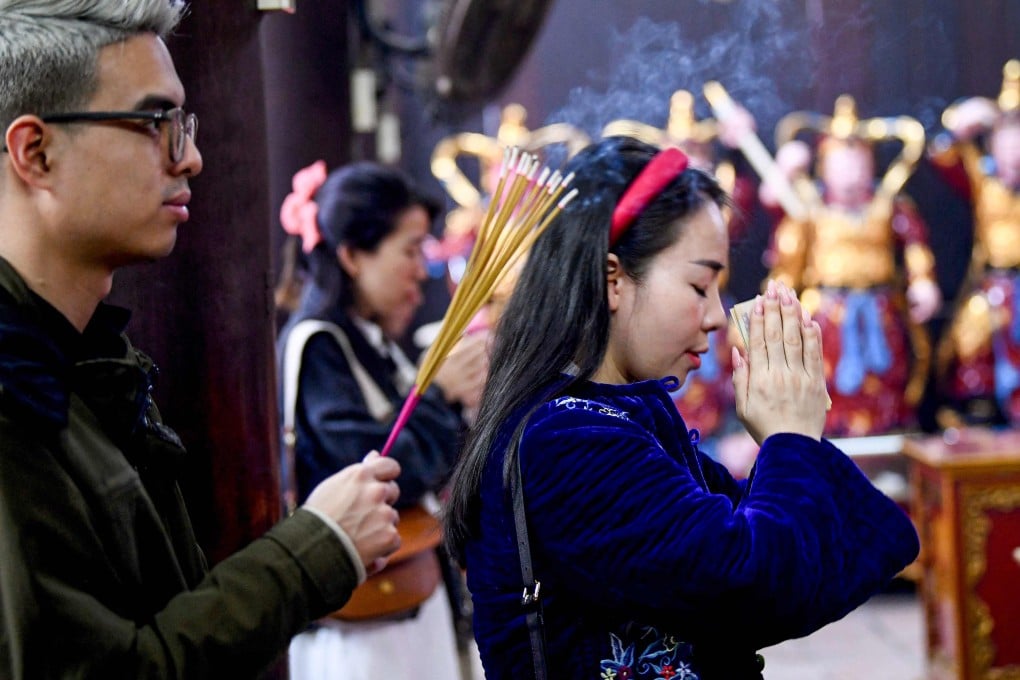Local residents pray to find love on Valentine’s Day at Ha Pagoda in Hanoi on February 14. Photo: AFP