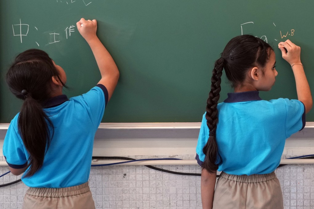 Pupils write on the chalkboard on the first day of the new school year at the Tsuen Wan Trade Association Primary School in Tsing Yi on September 4, 2023. Language barriers and other difficulties have held back those from ethnic minority communities from fully integrating into Hong Kong. Photo: Sam Tsang
