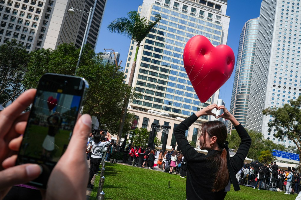 A visitor poses for pictures with a Chubby Heart in Central. Experts say more cultural events will attract tourists to the city. Photo: Sam Tsang
