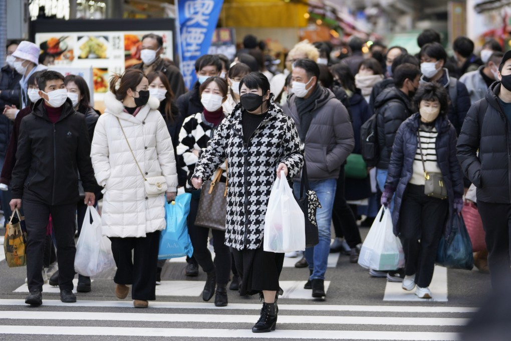 People cross a street in Tokyo’s Ueno district. Photo: AP