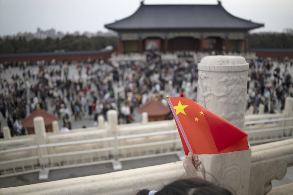 A girl holds a Chinese flag at the Temple of Heaven during Lunar New Year celebrations in Beijing on February 14. The US policy elite’s fantasy about the “democratisation of China” has taken root since the early days of Chinese reforms. Photo: EPA-EFE
