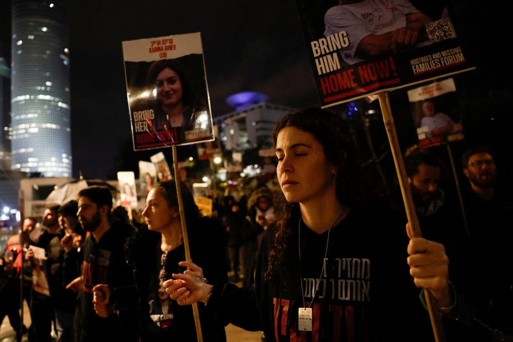 Relatives of Israeli hostages and supporters, who have handcuffed themselves to each other, hold placards during a protest calling for the hostages’ release in Tel Aviv on Thursday. Photo: Reuter