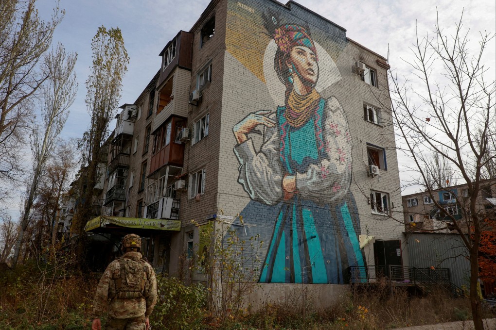 A Ukrainian serviceman walks next to a residential building heavily damaged by Russian military strikes in Avdiivka in November. Photo: Radio Free Europe/Radio Liberty via Reuters
