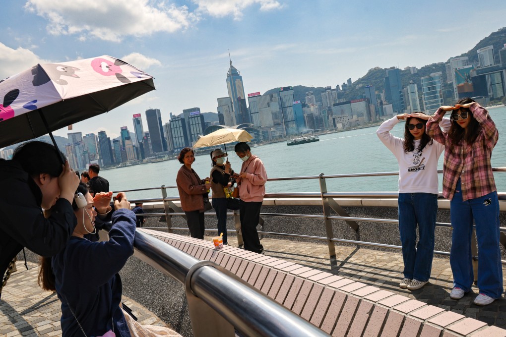 People pose for photos in Tsim Sha Tsui as the weather gradually becomes warmer. Photo: Jelly Tse