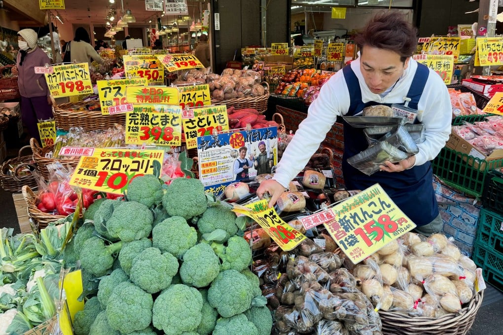 Store owner Hiromichi Akiba works at his supermarket in Tokyo on February 16. While swelling corporate coffers are enriching global investors. Japanese workers face stagnant wages. Photo: Reuters