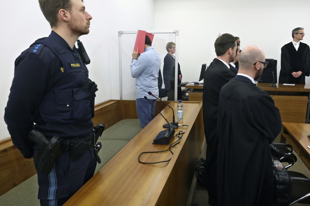 A 31-year-old American man accused of murder stands in the dock behind his lawyers in a courtroom at the district court in Kempten, Southern Germany. He on Monday admitted to charges of murder and rape after he allegedly pushed two US women down a ravine, fatally injuring one of them near Germany’s Neuschwanstein castle last year. Photo: AP
