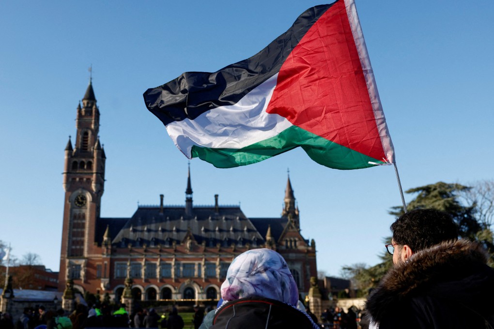 Protesters hold a Palestinian flag as they gather outside the International Court of Justice in The Hague, Netherlands. Photo: Reuters