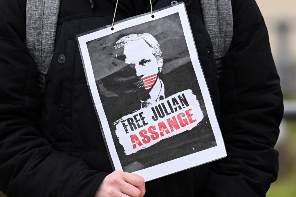 A person holds a placard, as supporters of WikiLeaks founder on the day he appeals in a British court against his extradition to the United States. Photo: Reuters