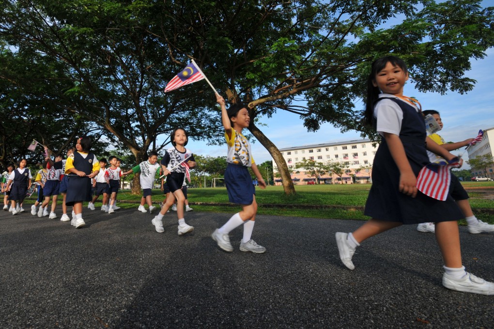 School children waving Malaysian flags. Malaysia’s Federal Court ruled it is legal for primary schools to teach in Mandarin, and Tamil. Photo : Malaysian Chinese Association/Handout