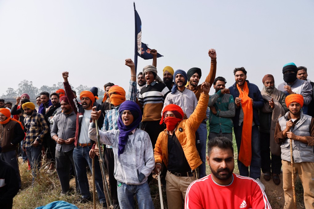 Farmers gesture at the police, at the protest site of farmers, who are marching towards New Delhi to press for the better crop prices promised to them in 2021. Photo: Reuters