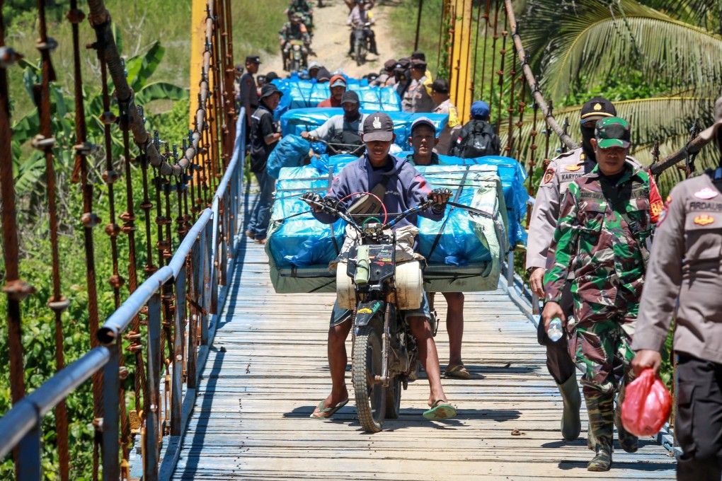 Workers with the logistics unit of Indonesia’s General Elections Commission (KPU) ride motorbikes to deliver election materials to remote polling stations in Lampung province earlier this month. Photo: AFP