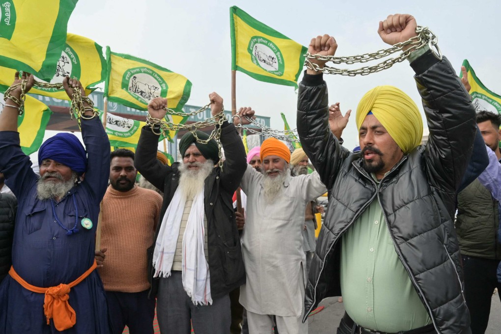 Farmers holding chains shout slogans during a protest demanding minimum support prices for all crops at a toll plaza on the outskirts of Amritsar. Photo: AFP