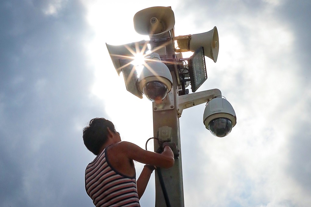 A worker installs a surveillance camera. Police are planning to install 15 sets of CCTV cameras in March. Photo: Felix Wong