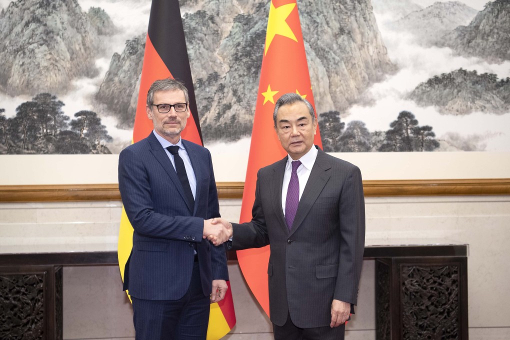 Chinese Foreign Minister Wang Yi (right) shakes hands with German foreign policy adviser Jens Plotner in Beijing on Friday. Photo: Xinhua