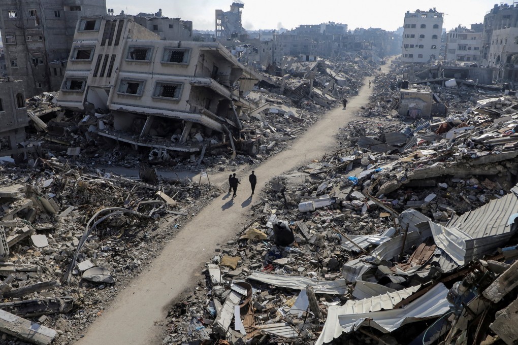 Palestinians walk past destroyed houses in the Jabalia refugee camp, northern Gaza Strip, on Thursday. Photo: Reuters