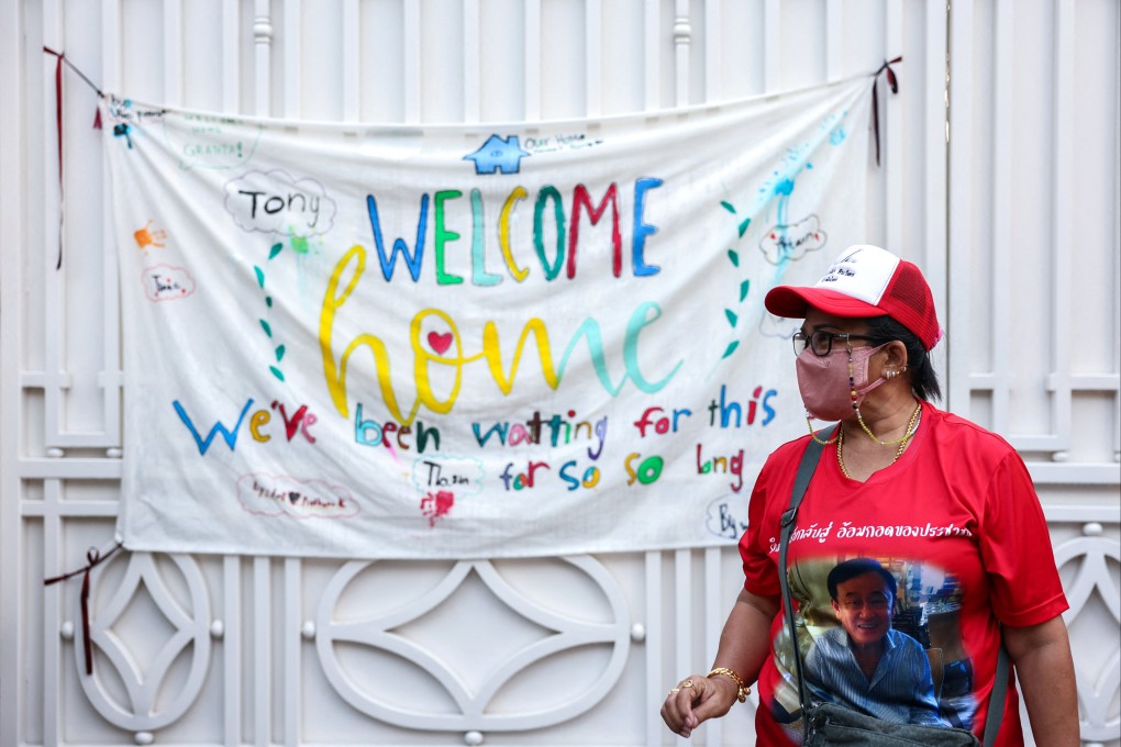 A supporter stands outside Thailand’s former prime minister Thaksin Shinawatra’s family compound after he arrives from a police hospital after being granted parole. Photo: Reuters