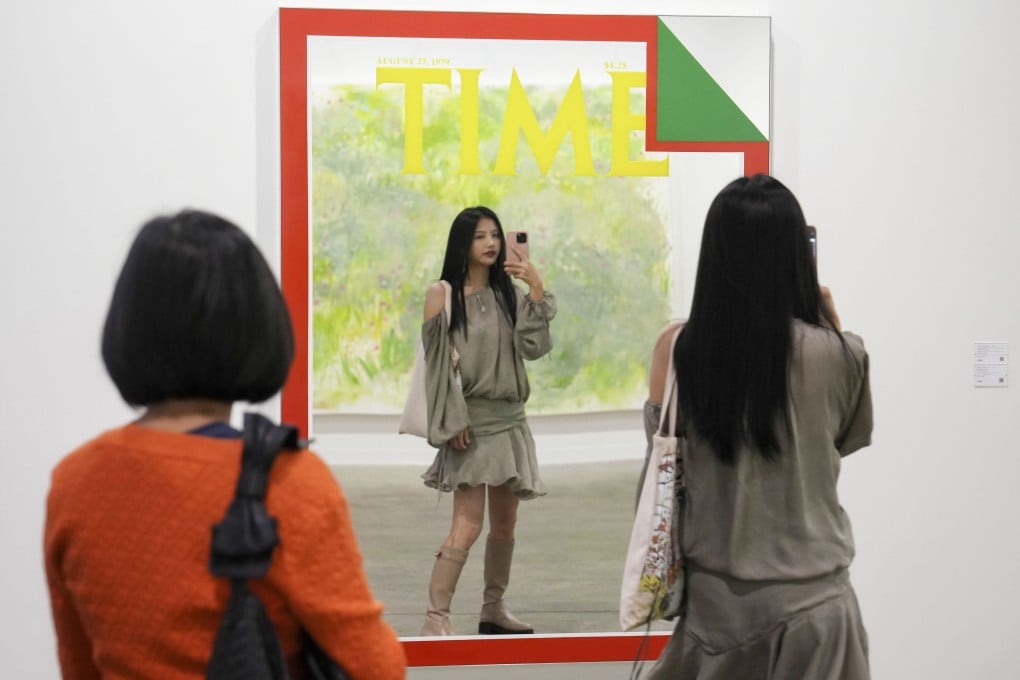 A visitor takes a selfie in front of “August 27, 1979 (The Topsy-Turvy Economy),” (2022) at Art Basel Hong Kong 2023. The 2024 fair will focus on young people with spending power, with another theme being dialogue and tension between East and West. Photo: Elson Li
