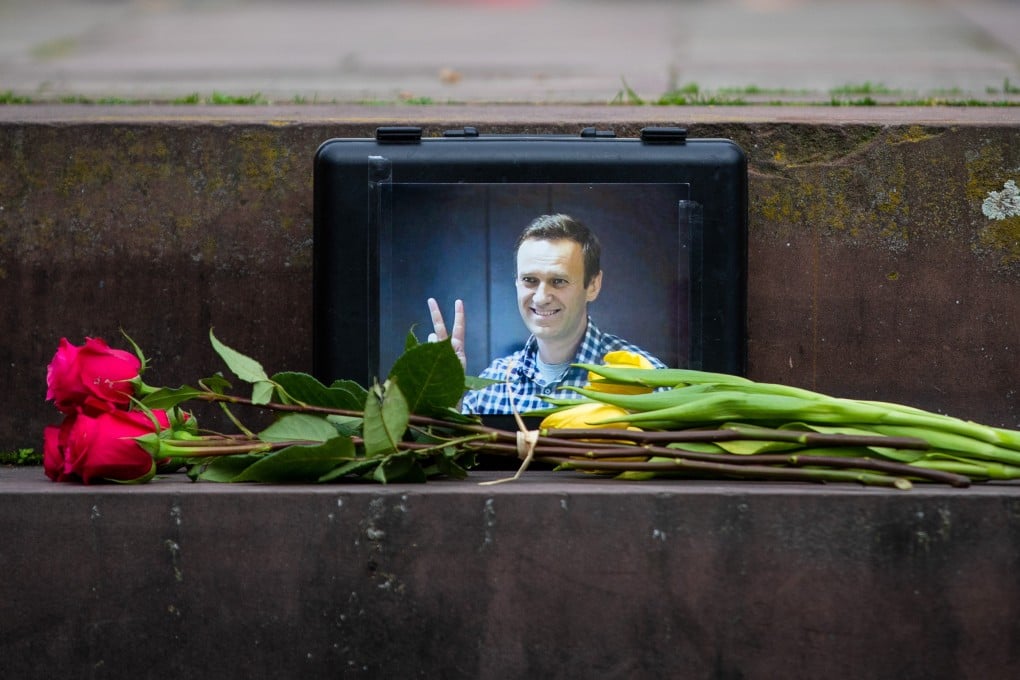 Flowers lie in front of a picture of the late Russian opposition figure Alexei Navalny, in Stuttgart. Photo: dpa